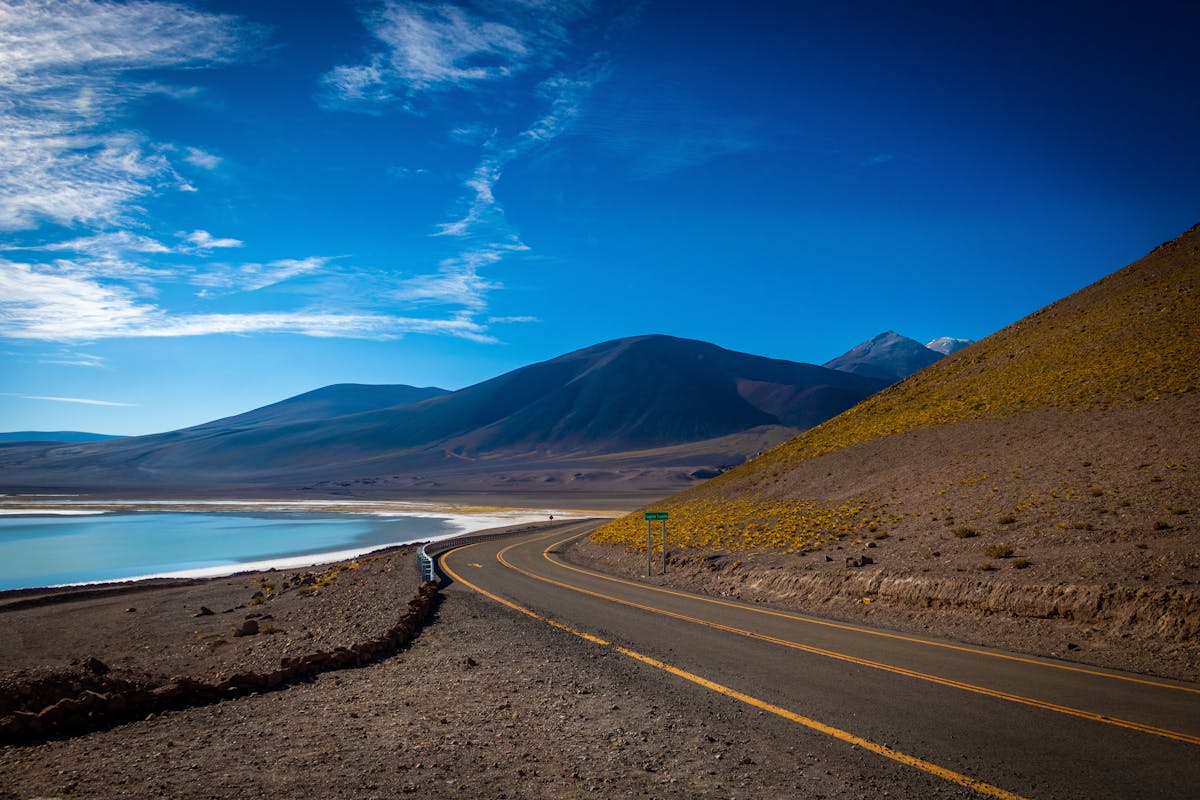 Winding road through the Atacama Desert with mountains and clear blue sky in Chile