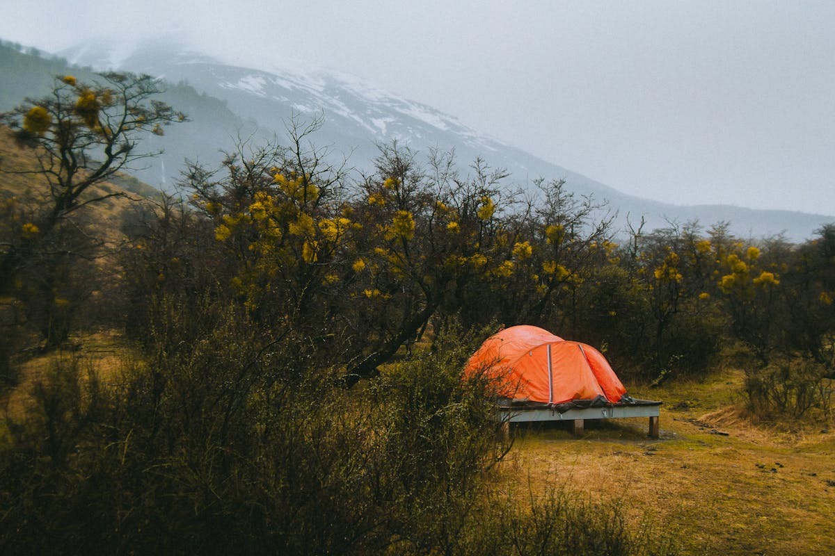Tent pitched beside a lake with Patagonian mountains in the distance