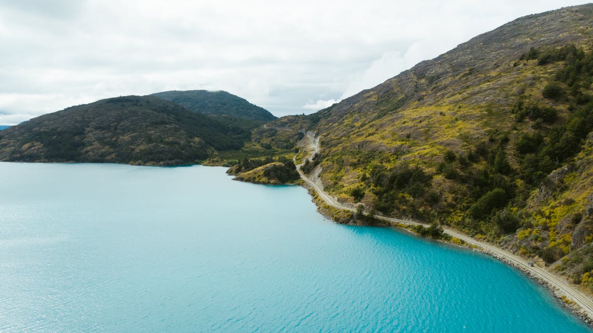 Aerial view of road alongside a lake with forests in Puerto Montt Chile