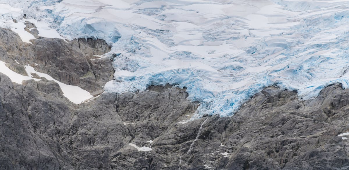 Glacier surrounded by rugged mountain rocks in Patagonian landscape