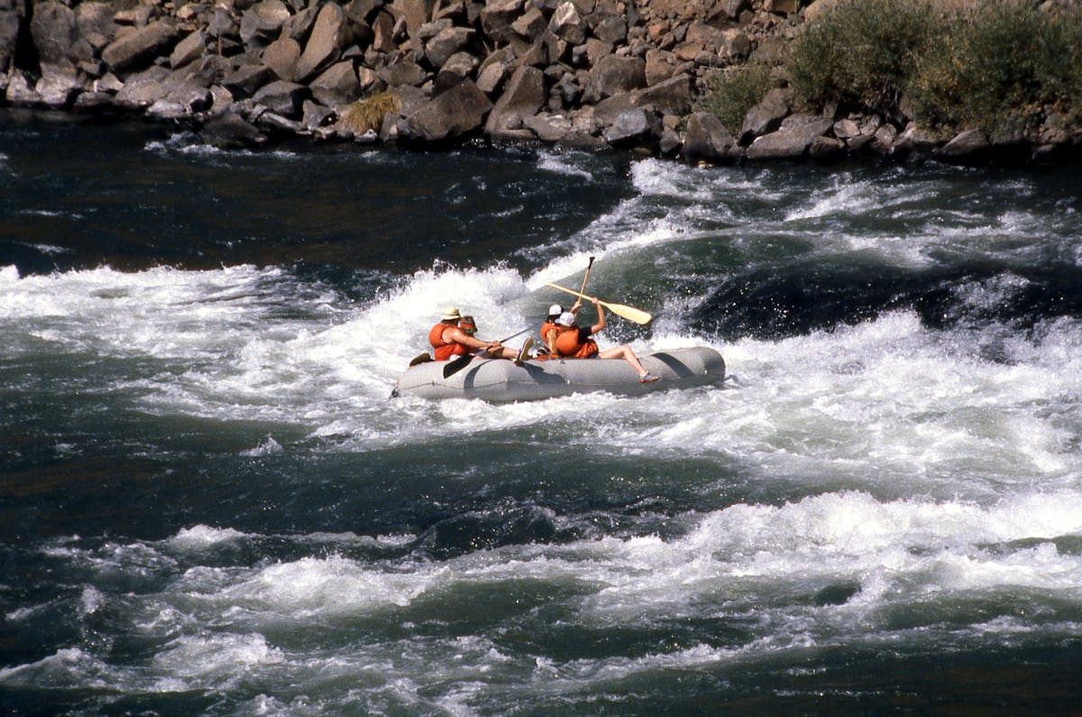 Whitewater rafting through rapids on a scenic mountain river
