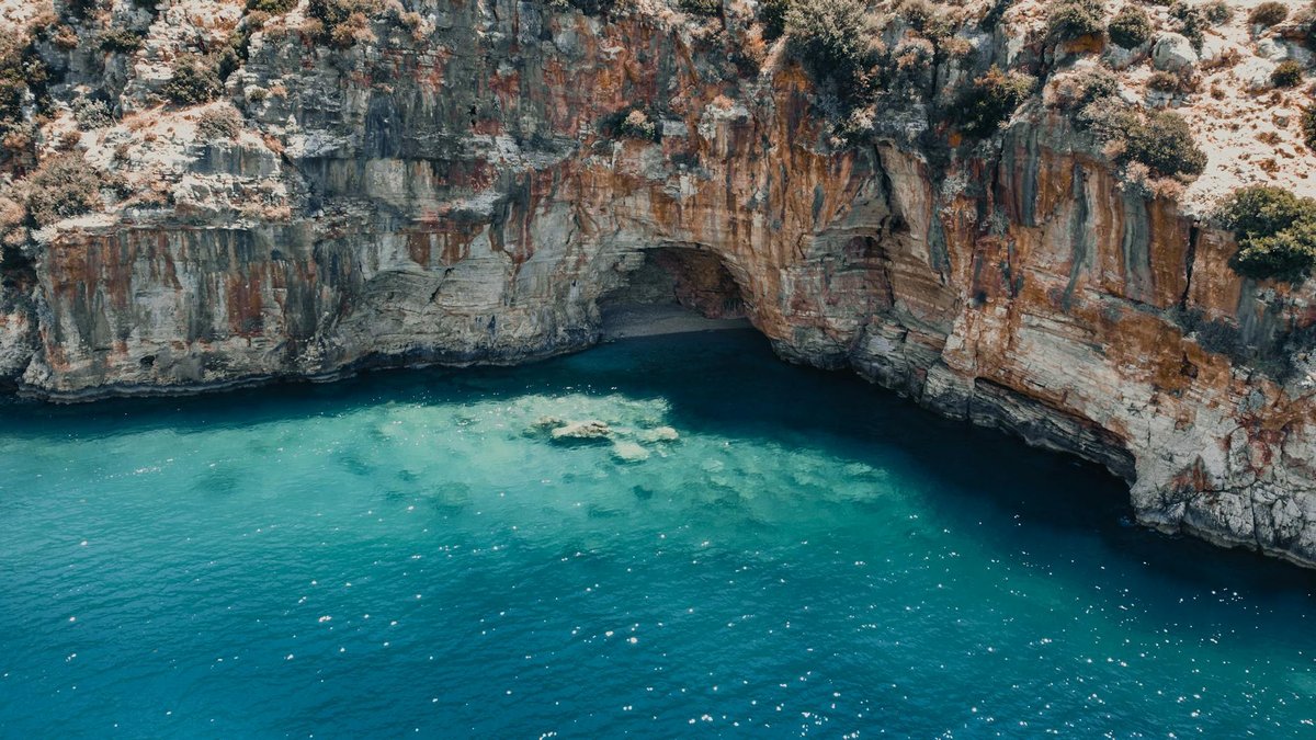 Secluded cove with crystal clear turquoise water and white sand beach
