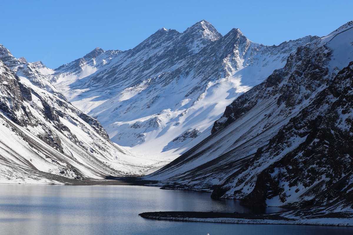 Snow-covered Andes mountains and serene lake during Chilean winter