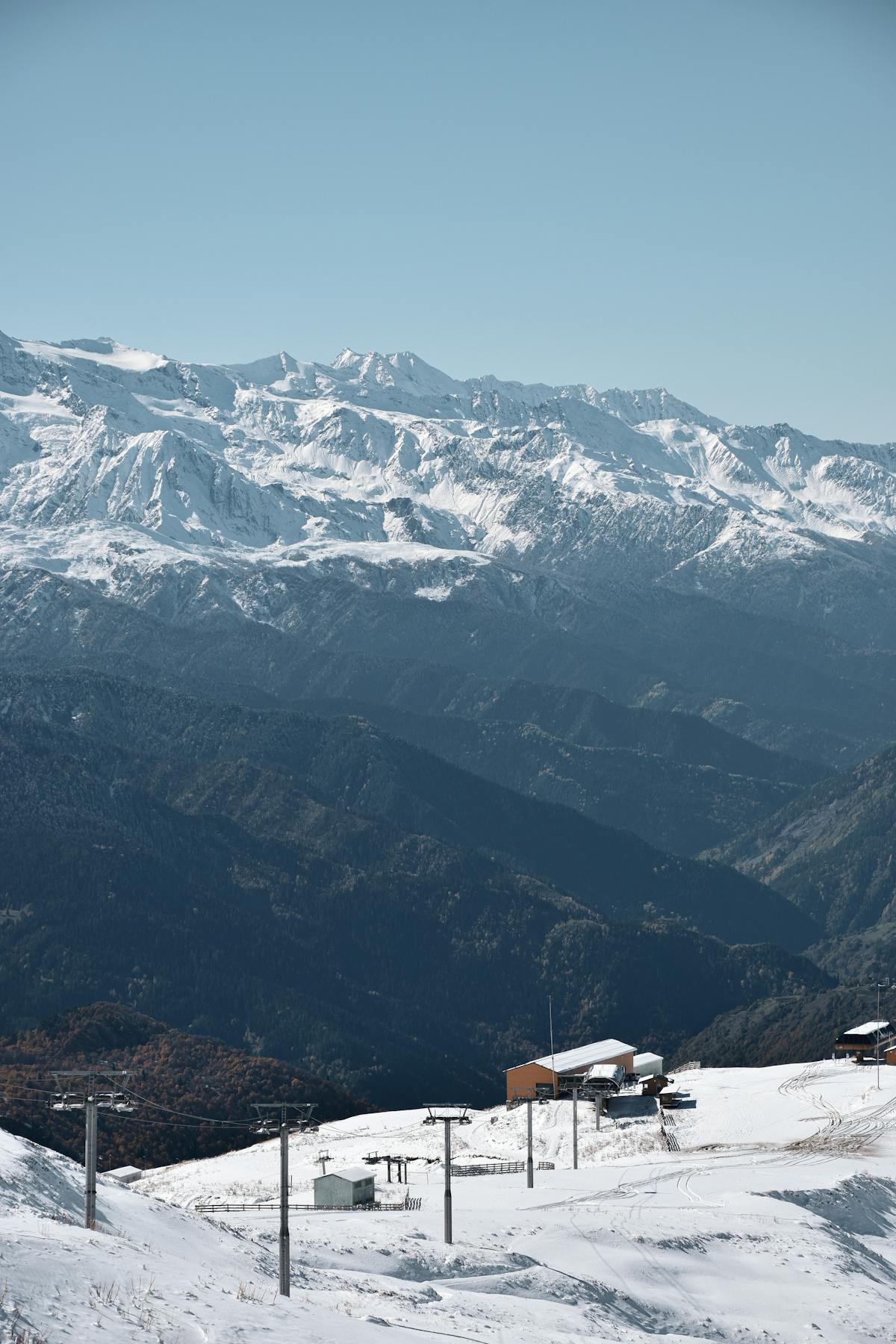 Panoramic view of snowy mountains and ski resort terrain in winter
