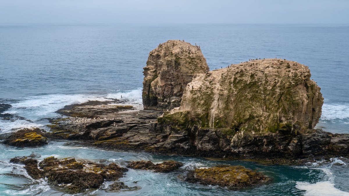 Rocky coastline in Chile with ocean waves crashing against dramatic cliffs