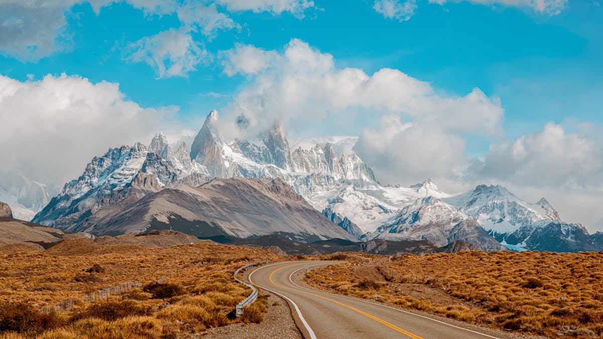 Winding road leading toward the jagged peaks of Mount Fitz Roy in Patagonia