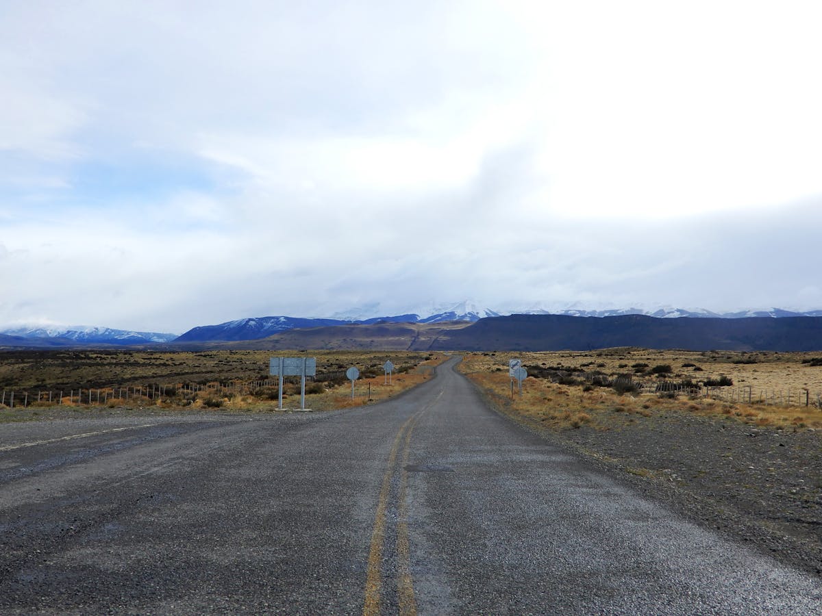 Empty rural road leading toward Torres del Paine mountains in Chilean Patagonia