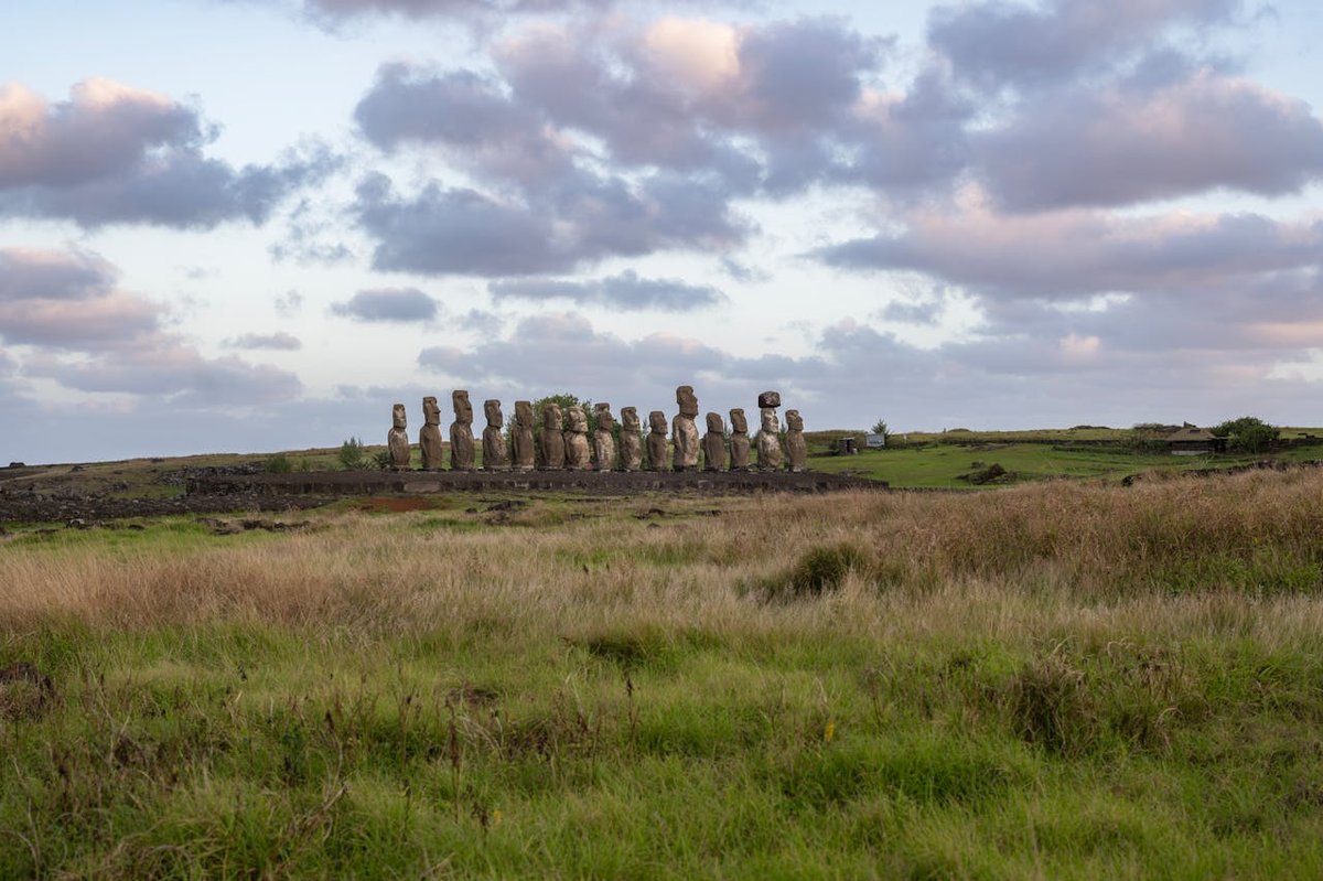 Moai statues at Ahu Tongariki during sunset on Easter Island with warm golden light