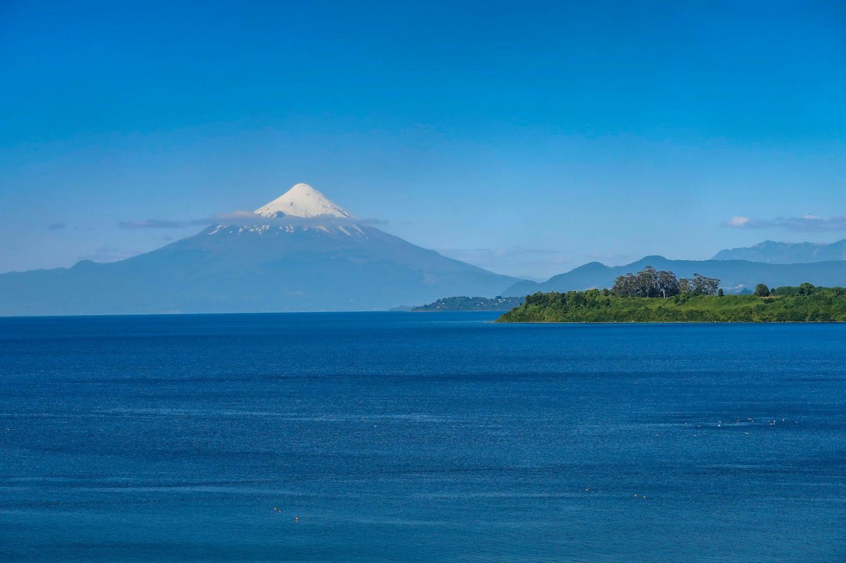 Osorno Volcano towering over Lake Llanquihue under clear blue sky in Chile's Lake District