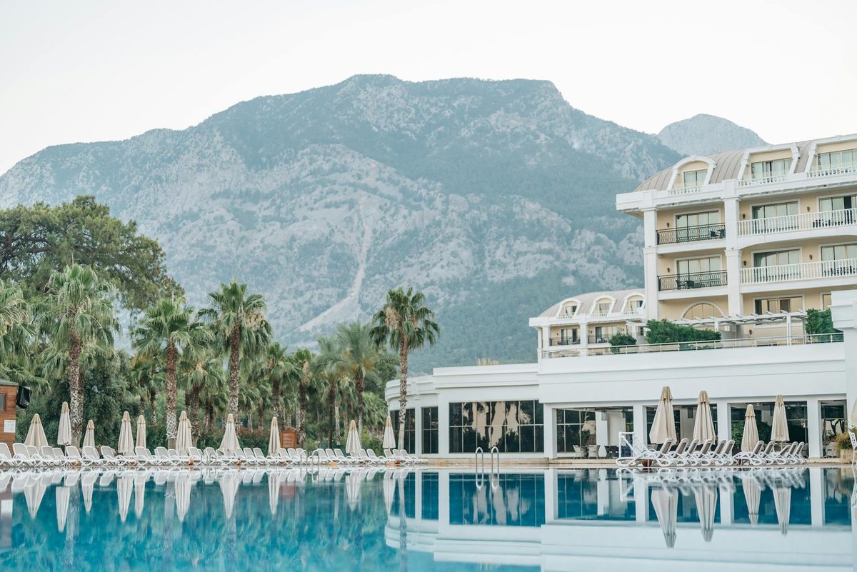 Luxury hotel pool area with mountain backdrop and inviting lounge setting