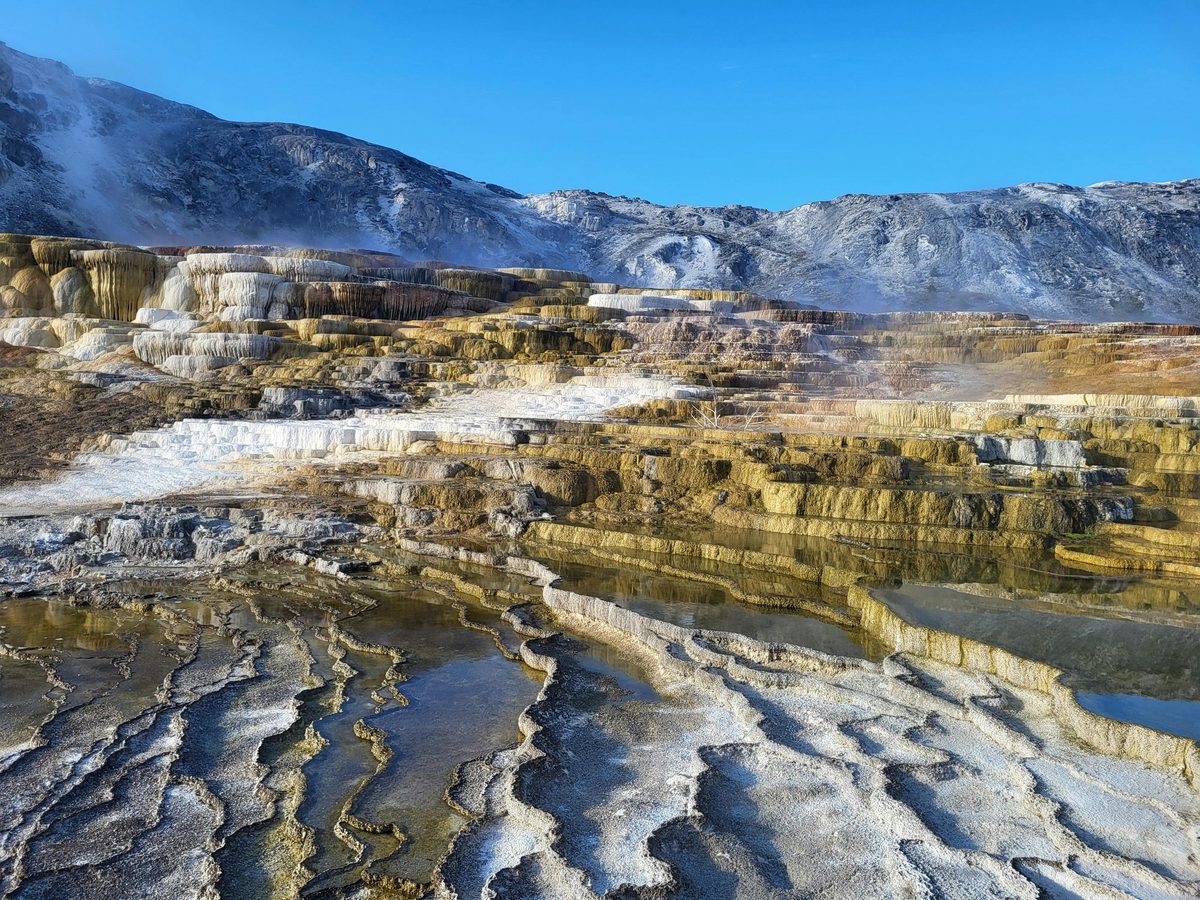 Colorful geothermal terraces with mineral deposits and steaming water