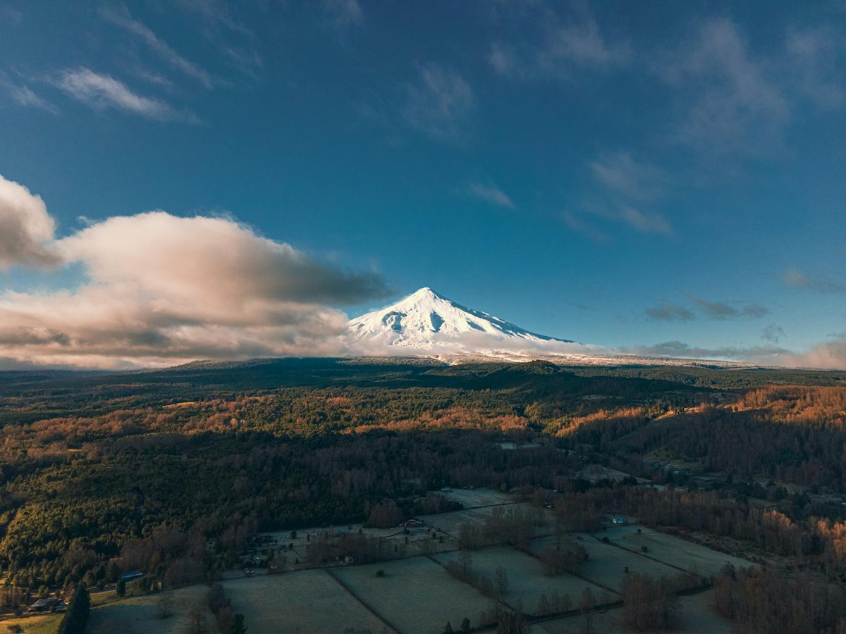 Aerial view of snowcapped Villarrica Volcano with surrounding forests