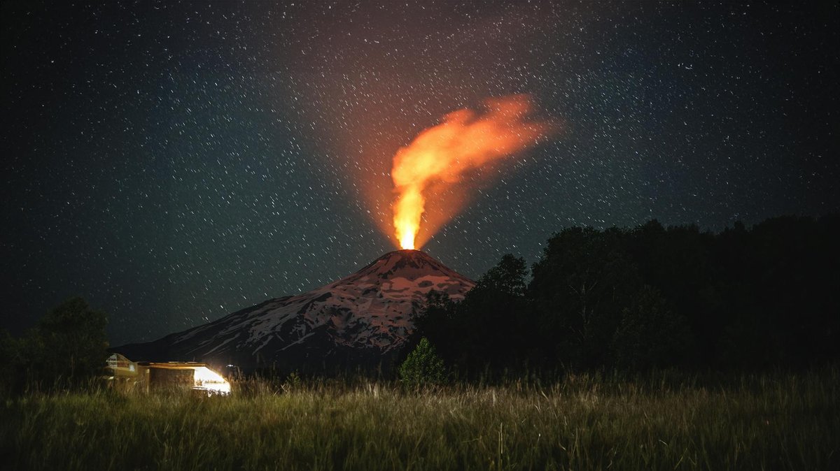 Villarrica Volcano glowing at night under starry sky