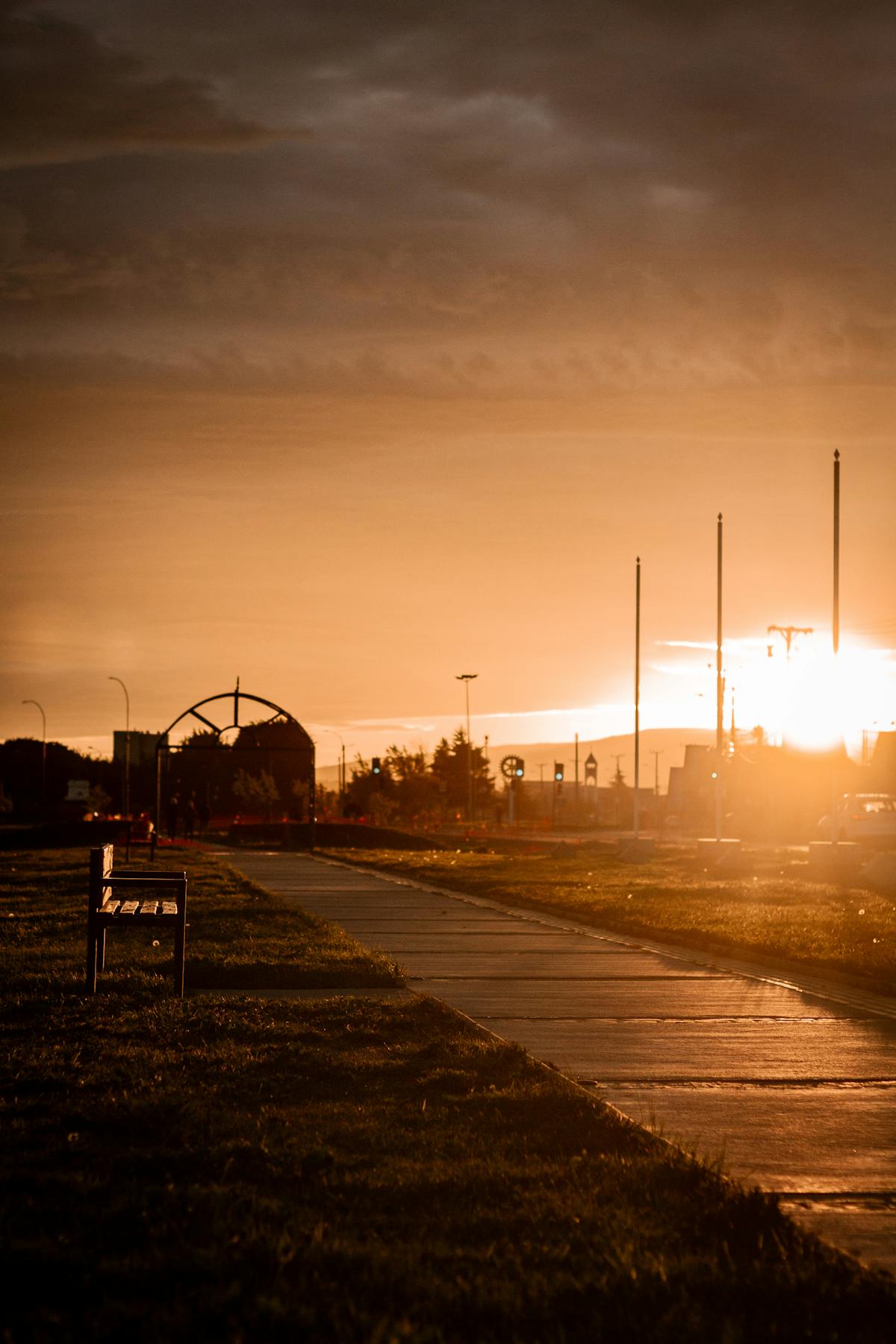 Golden hour sunset view over a park walkway in Punta Arenas with warm light over the Strait of Magellan