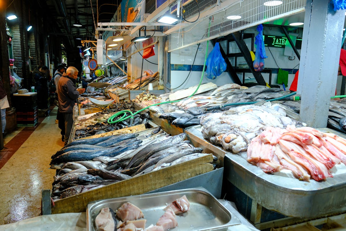 Busy fish market in Santiago with fresh seafood displays and local shoppers
