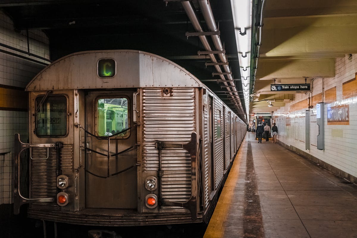 Subway train at an urban station platform with passengers