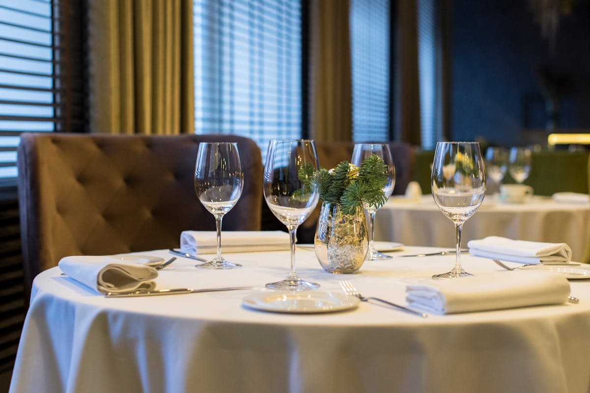 Elegant fine dining table setting with polished wine glasses and white napkins