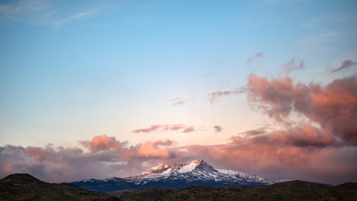 Torres del Paine mountains at sunrise with colorful clouds over snow-covered peaks