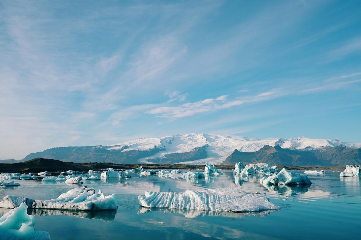 Blue icebergs floating in a glacial lake surrounded by mountains