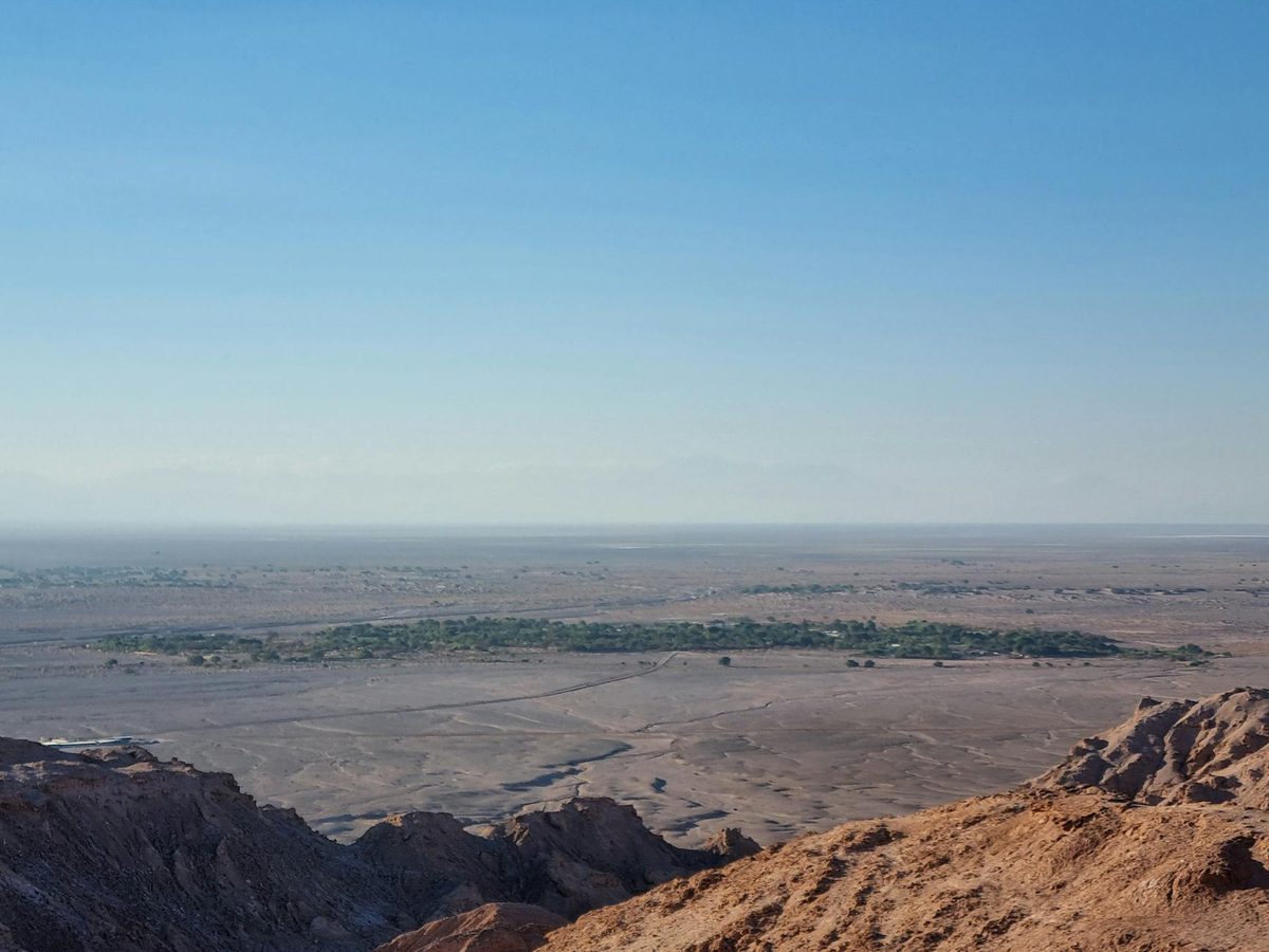 Breathtaking view of the Atacama Desert showcasing its vast, arid landscape under a clear blue sky.