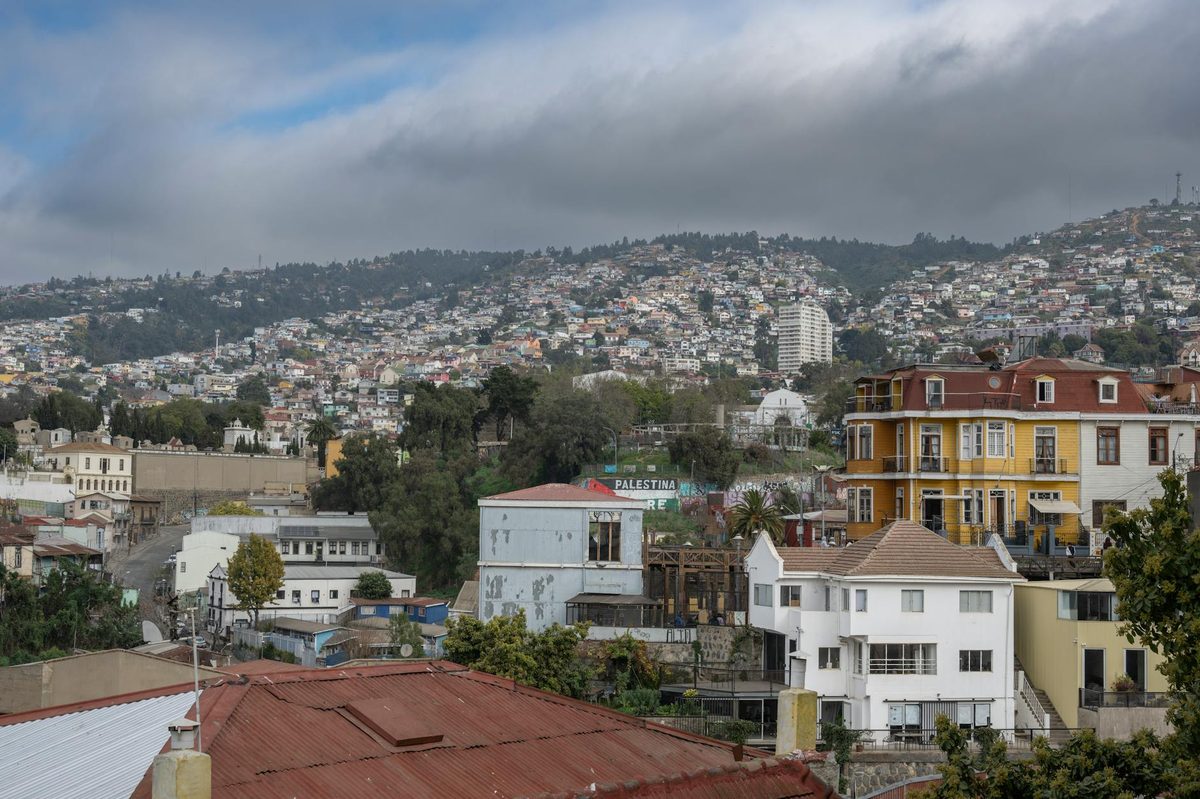View of vibrant hillside houses in ValparaÃƒÂ­so, Chile, under cloudy skies.